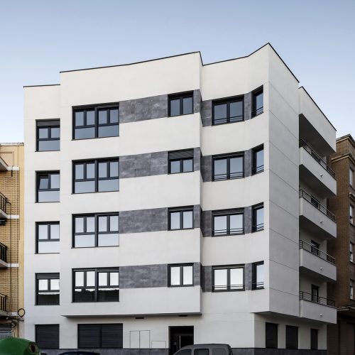 Fachada con bandas cerámicas grises y ventanas modulares de edificio proyectado por arquitectos Valencia