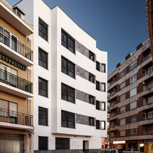 Fachada blanca con bandas cerámicas grises diseñada por estudio de arquitectura en Valencia