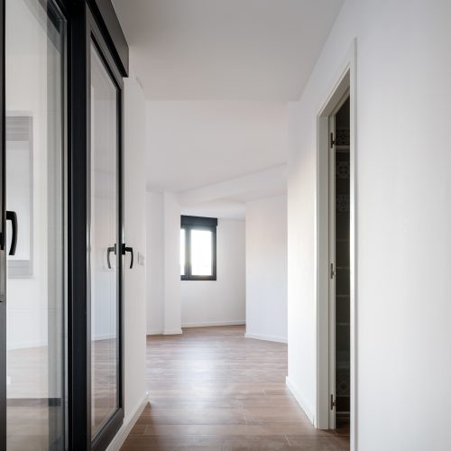 Paso interior con luz natural y suelo cerámico en vivienda de proyectos de arquitectura residencial en Valencia