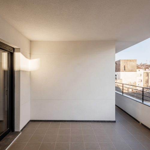 Terraza privada con barandilla metálica y cerramiento blanco diseñada por arquitecto para vivienda unifamiliar en Valencia