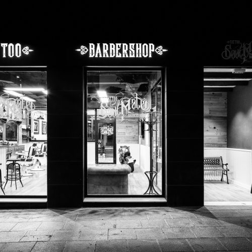 Fachada nocturna con acceso retranqueado diseñada por estudio de arquitectura Valencia para local comercial