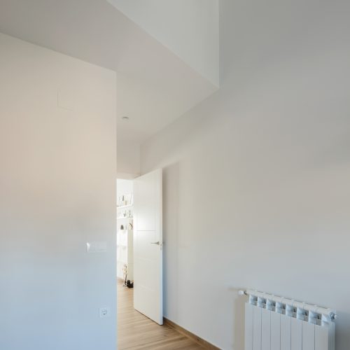 Distribuidor interior con techo inclinado, pavimento de madera y calefacción eficiente, presupuesto arquitecto Valencia