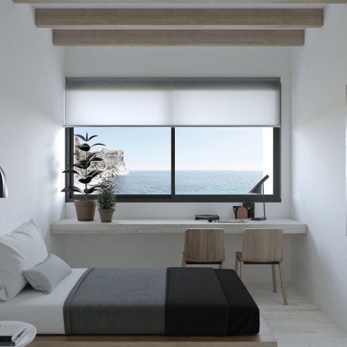Dormitorio con escritorio y ventana panorámica al mar en casas modulares Valencia proyectada por Alfaro Arquitectos