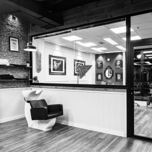 Zona de lavado y cerramiento acristalado diseñada por estudio de arquitectura en Valencia para barbería