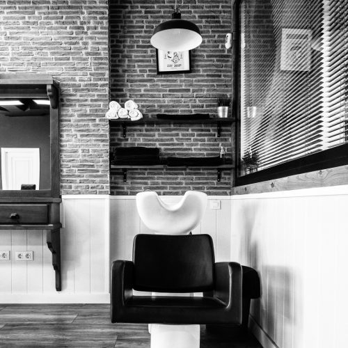 Zona de lavado en barbería con ladrillo visto y mobiliario técnico diseñada por arquitecto en Valencia