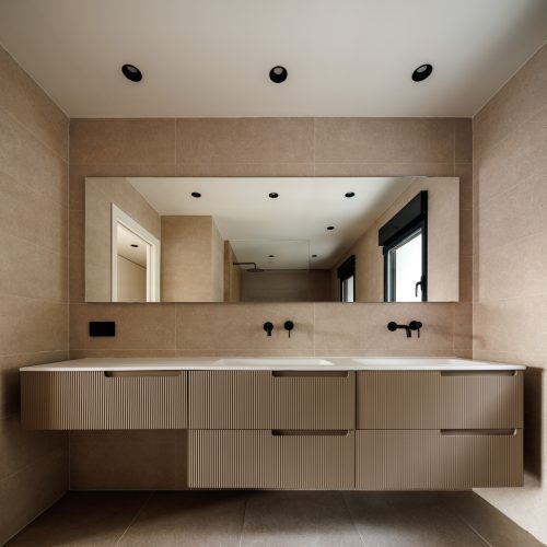 Diseño de interiores en baño principal con mueble suspendido texturizado, espejo longitudinal y grifería empotrada en reforma unifamiliar