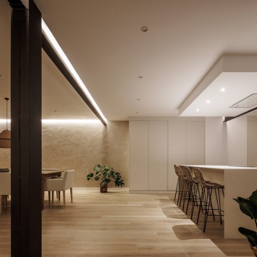 Zona de comedor y cocina con acabados neutros y soluciones técnicas por el estudio de arquitectura en Valencia
