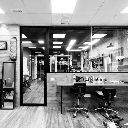 Espacio de trabajo del estudio de tatuaje con fondo acristalado diseñado por arquitectos Valencia