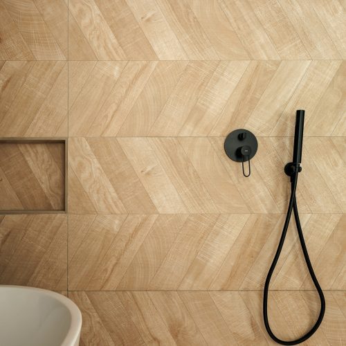 Detalle de revestimiento cerámico en espiga y grifería negra en baño reformado de vivienda unifamiliar, arquitectura residencial