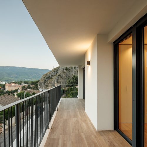 Terraza con pavimento cerámico efecto madera y barandilla metálica en reforma integral de vivienda unifamiliar