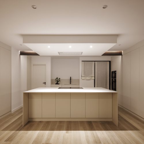 Vista frontal nocturna de cocina con isla central diseñada por arquitecto en Valencia