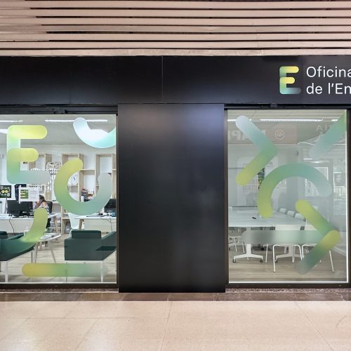 Fachada de vidrio serigrafiado de la Oficina de la Energía, diseñada por arquitectos Valencia con espacios de atención e interior visibles.