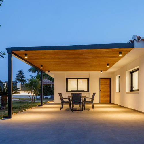 Porche exterior iluminado al anochecer en vivienda unifamiliar reformada por arquitecto Valencia