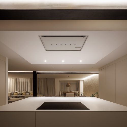 Cocina con isla central y acabados neutros, ejemplo de arquitectura de calidad en Valencia