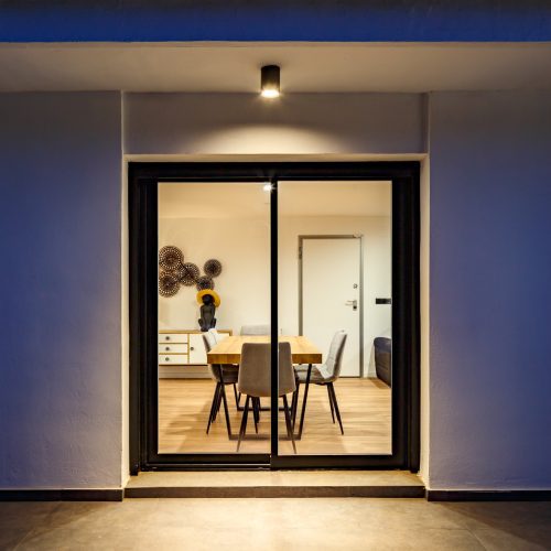 Vista nocturna desde el porche hacia el comedor interior de una vivienda reformada por estudio de arquitectura Valencia