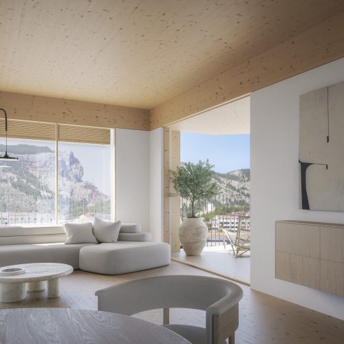 Interior con estructura de CLT y vistas al paisaje en proyecto sostenible de vivienda pública por arquitecto en Valencia
