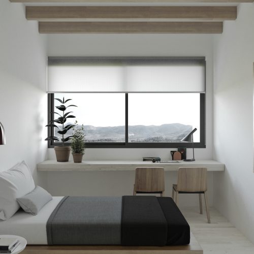 Dormitorio con escritorio y vistas al paisaje en vivienda modular proyectada por estudio de arquitectura Valencia