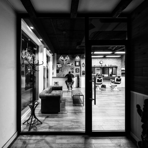 Interior entre zonas de espera y barbería diseñada por contratar arquitecto en Valencia