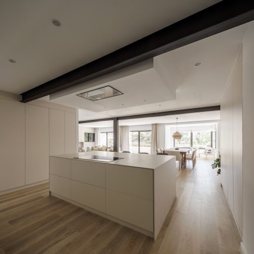 Cocina con isla central y estructura metálica vista en reforma integral por arquitecto en Valencia