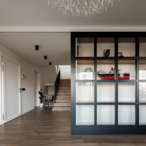 Arquitectos Valencia en diseño de acceso interior con estantería de vidrio, escalera de madera y distribución racional en Villa Muntanya
