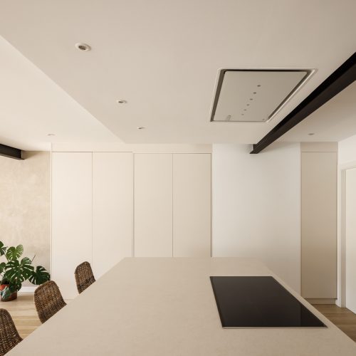 Cocina con isla y mobiliario integrado en reforma integral por arquitectos en Valencia