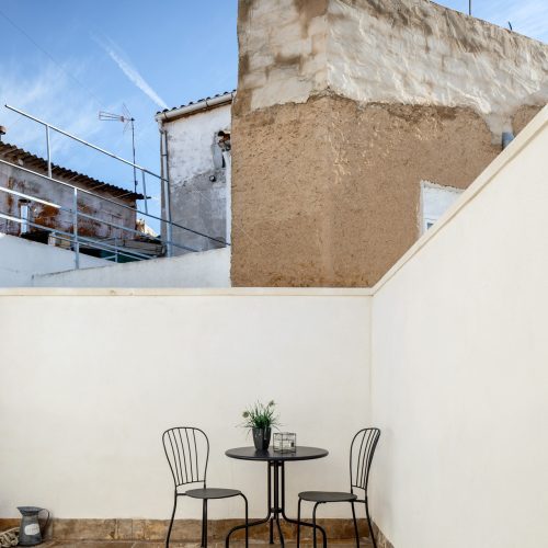 Terraza en planta superior con cerramiento blanco y pavimento pétreo, arquitecto obra nueva Valencia
