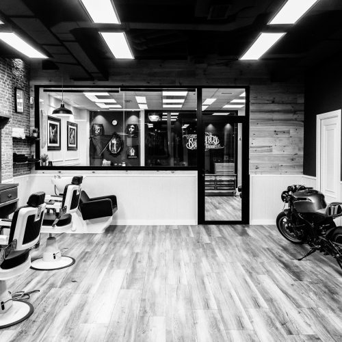 Vista general de barbería en reposo con fondo acristalado proyectada por arquitecto reformas integrales Valencia