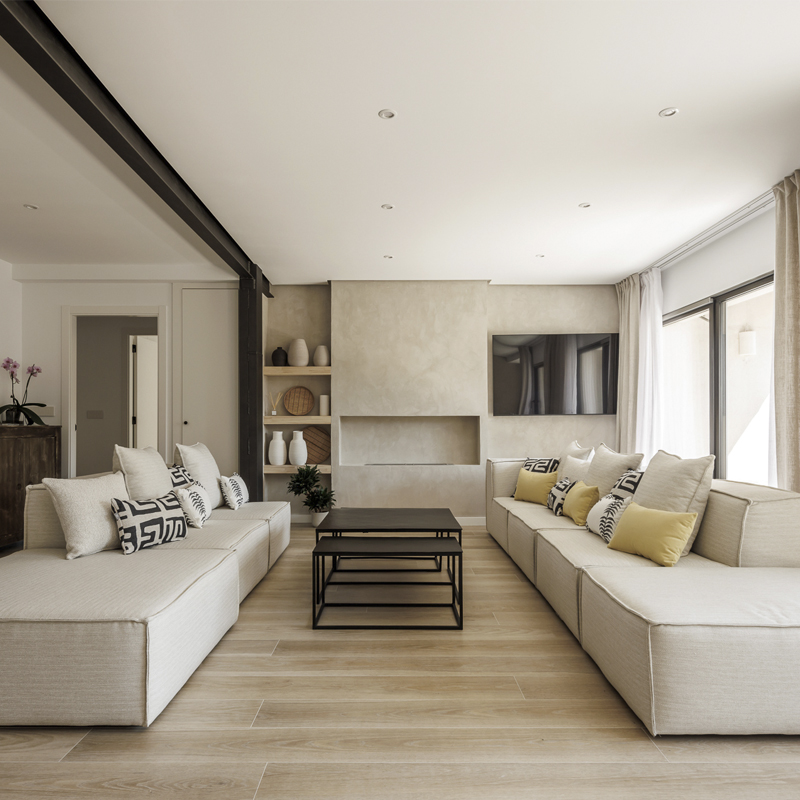 Salón principal con estructura metálica vista y luz natural en reforma integral por arquitecto en Valencia