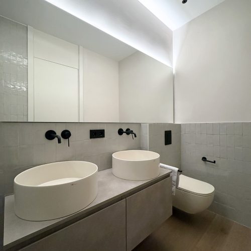 Lavabo doble y revestimiento cerámico en baño de reforma integral realizada por arquitecto en Valencia