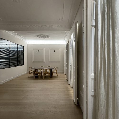 Comedor con molduras restauradas, carpintería original y mampara metálica acristalada en proyecto de arquitectura residencial en Valencia