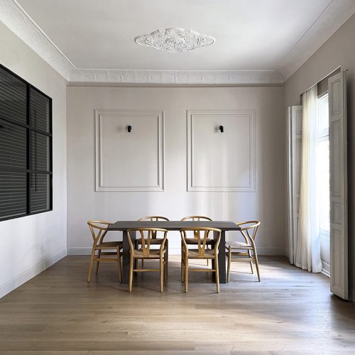 Comedor con carpinterías restauradas, pavimento continuo y molduras originales en proyecto de arquitectura de interiores en el Ensanche de Valencia
