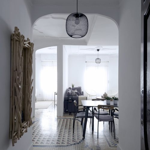 Recibidor con distribución abierta, mosaico de noya restaurado y solución de diseño de interiores en vivienda de Ciutat Vella