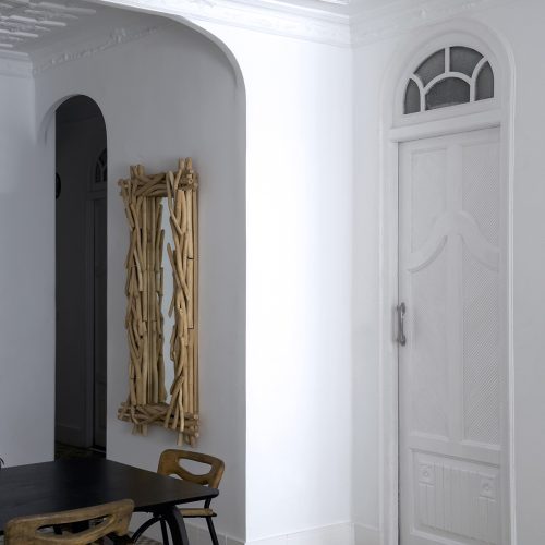Detalle de reforma interior en Valencia con puerta original restaurada, molduras decorativas y suelo de mosaico Nolla.
