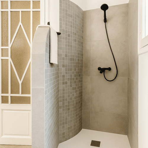 Ducha de obra con mosaico gris y grifería en negro mate, diseñada por arquitecto en Valencia con un estilo contemporáneo.