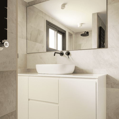 Baño con mueble blanco, lavabo sobre encimera y grifería negra diseñado por arquitecto en Valencia