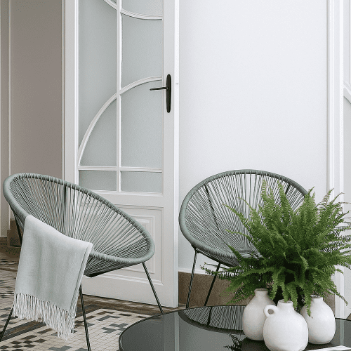 Butacas de cuerda verde junto a mesa circular negra en salón, reformado por estudio de arquitectura Valencia con estilo contemporáneo.
